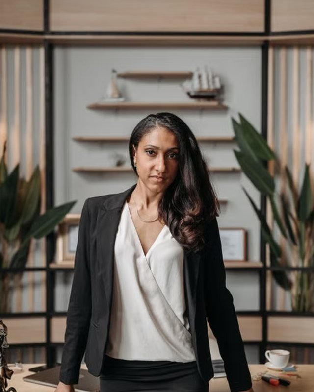 Portrait of Priya Sen standing in an office with shelves behind her